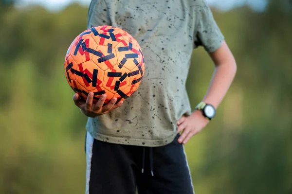 Vista Perto Adolescente Segurando Uma Bola Futebol Laranja Tiro Seu — Fotografia de Stock