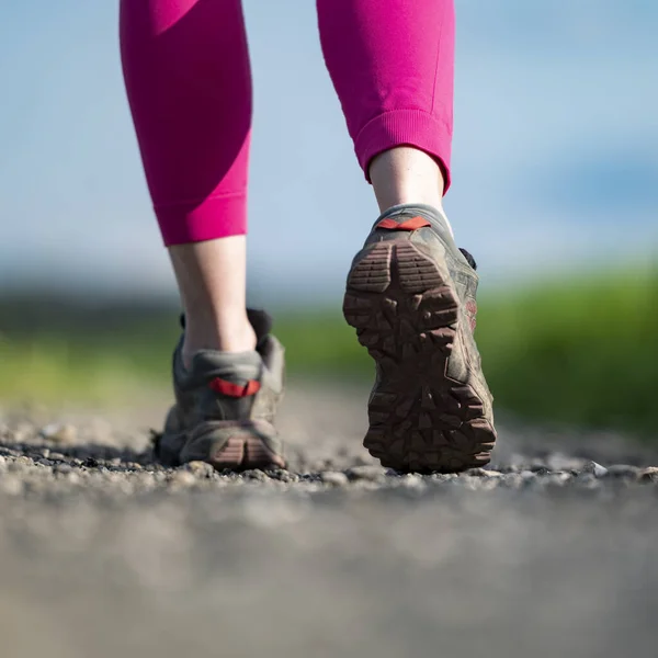 远足鞋女腿踩在砾石路上的低角度特写 — 图库照片