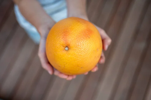孩子手里拿着成熟的 多汁的大柑橘或柚子的头像 — 图库照片