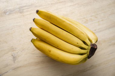 Ahşap yüzeye yerleştirilmiş taze organik muzlar..