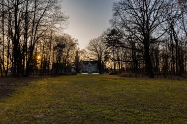 Wroclaw, Poland - March 2022: Small cute Pawlowice park with beautiful palace on the border of Wroclaw at sunset