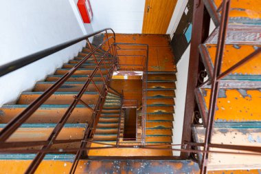 Look down to old high square spiral stairscase in old tenement building