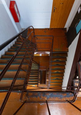 Look down to old high square spiral stairscase in old tenement building