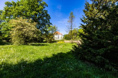 Wroclaw, Poland - May 2022: Beautiful an old castle in Lesnica with a cultural center with exhibitions of works by Polish artists and illustrators with colorful park around