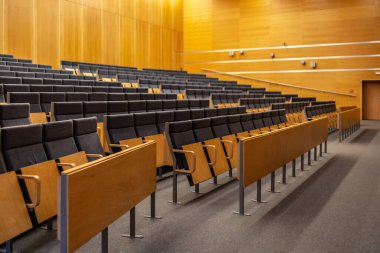 Wroclaw, Poland - May 2022: Interior of big conference hall of Wroclaw University of Science and Technology full of gray folding chairs and wooden walls