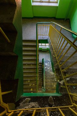 Terk edilmiş eski bir binada eski bir dikdörtgen spiral merdivenin üst görüntüsü