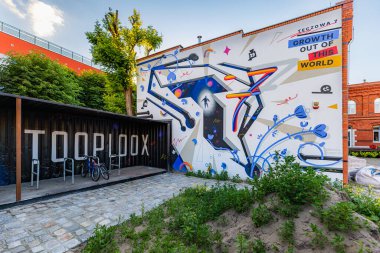 Wroclaw, Polonya - Haziran 2022: Kırmızı tuğla bir binanın duvarında büyük ve renkli bir Tooploox reklam tablosu