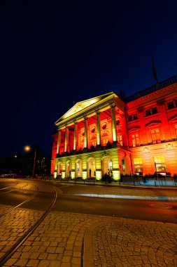 Wroclaw, Polonya - Haziran 2022: Wroclaw Opera Binası Koyu bir yaz akşamında sarı ve kırmızı renkli ışıklarla aydınlatıldı