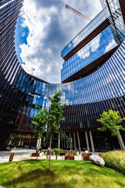 Poznan, Polonya - Temmuz 2022: Nowy Rynek kompleksine ait cam bir binanın ortasında güzel küçük yeşil bir kare