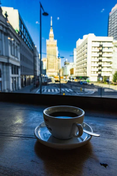 ポーランド ワルシャワ 2022年7月 グリーンカフェ ネロの黒いコーヒーカップ文化科学宮殿につながる直線道路の眺め — ストック写真