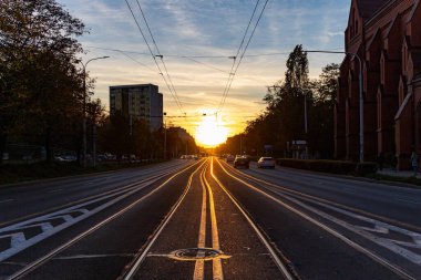 Wroclaw, Polonya - Ekim 2022: Uzun Grabiszynska caddesinin hemen üzerinde gün batımında güzel bir gün batımı tramvay rayları ve tramvayla