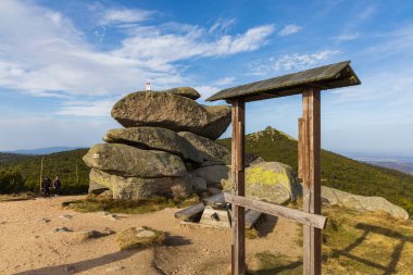 Dağ yolunun yanında küçük bir dinlenme yeri, küçük ahşap bank ve büyük taşların yanında masa ve bilgi tahtası için küçük ahşap çerçeve.