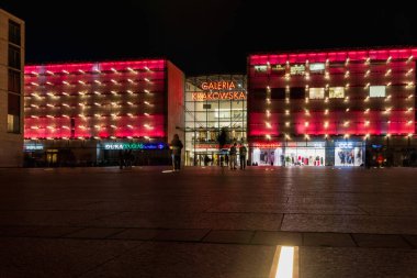 Krakow, Polonya - 23 Mart 2023: Krakow alışveriş merkezinin güzel ve renkli ön cephesi karanlık öğleden sonra ana tren istasyonu üzerinde