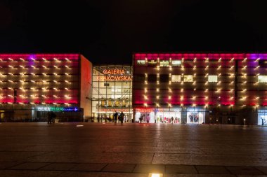 Krakow, Polonya - 23 Mart 2023: Krakow alışveriş merkezinin güzel ve renkli ön cephesi karanlık öğleden sonra ana tren istasyonu üzerinde