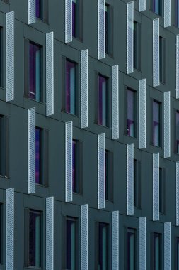 Pencerelerde renkli yansımaları olan modern şirket binasının cephesine bakış açısı
