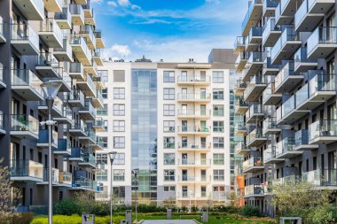 Wroclaw, Polonya - 15 Nisan 2023: Yeni modern malikanenin yansıtıcı cam balkonlarına sahip iki modern apartman bloğunun cepheleri arasında uzun tuğla yol