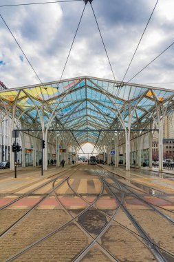 Lodz, Polonya - 20 Nisan 2023: Tek boynuzlu at durağı, şehir merkezindeki renkli ve dekoratif tramvay istasyonu, bulutlu bir sabah, sarı ve kırmızı tramvaylarla