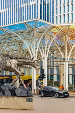 Lodz, Polonya - 20 Nisan 2023: Tek boynuzlu atın çelik heykeli Tomohiro Inaba tarafından şehir merkezinde tek boynuzlu at ahırı adı verilen renkli tramvay istasyonunun yanında havada eriyor.