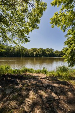 Nehrin yanında güzel, küçük bir meydan dinlenmek için patikanın yanında güzel yeşil bir çevrede.