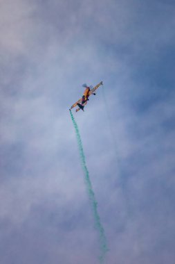 Leszno, Polonya - 16 Haziran 2023: Antidotum Airshow Leszno 2023 ve Marek Choim 'in bulutlu gökyüzünde uçan 330SC uçağında renkli dumanlarla dolu akrobatik gösterileri