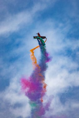 Leszno, Polonya - 16 Haziran 2023: Antidotum Airshow Leszno 2023 ve Marek Choim 'in bulutlu gökyüzünde uçan 330SC uçağında renkli dumanlarla dolu akrobatik gösterileri
