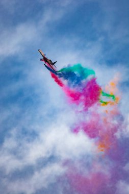 Leszno, Polonya - 16 Haziran 2023: Antidotum Airshow Leszno 2023 ve Marek Choim 'in bulutlu gökyüzünde uçan 330SC uçağında renkli dumanlarla dolu akrobatik gösterileri