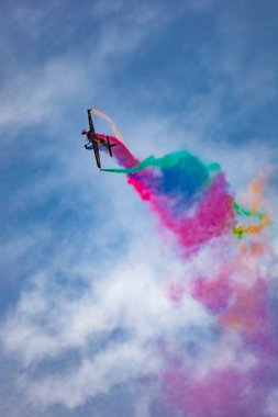 Leszno, Polonya - 16 Haziran 2023: Antidotum Airshow Leszno 2023 ve Marek Choim 'in bulutlu gökyüzünde uçan 330SC uçağında renkli dumanlarla dolu akrobatik gösterileri