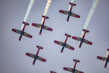 Leszno, Polonya - 16 Haziran 2023: Antidotum Airshow Leszno 2023 ve bulutlu bir gökyüzünde PC-7 uçak ekibi dumanı dolu akrobatik gösteriler