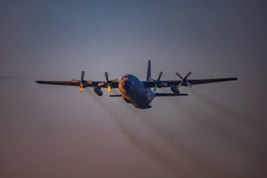 Leszno, Polonya - 16 Haziran 2023: Antidotum Airshow Leszno 2023 ve bulutlu gökyüzünde C-130 Herkül uçağı dumanı dolu akrobatik gösteriler