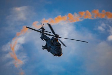 Leszno, Polonya - 16 Haziran 2023: Antidotum Hava Şovu Leszno 2023 ve akrobatik gösteriler bulutlu bir gökyüzünde Süper Puma Ekran Ekibi helikopteri dumanı ile dolu