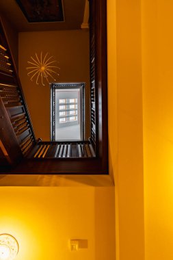 Gdansk, Polonya - 23 Temmuz 2023: Şu anda aparthotel olan eski bira fabrikası Hevelius 'un içinde ahşap korkuluklar ve tavan pencereleri bulunan güzel yenilenmiş spiral kare merdivenlere bakın.