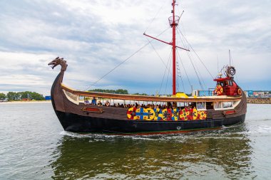 Wladyslawowo, Polonya - 24 Temmuz 2023: Güzel tahta Viking teknesi Rakkar bulutlu bir günde Baltık Denizi 'nde turistlerle dolu