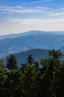 Güzel yeşil ve mavi dağ katmanları ve ağaçlar ve bu bölgedeki en yüksek dağdaki kulenin tepesinden görülen bazı tarlalar.