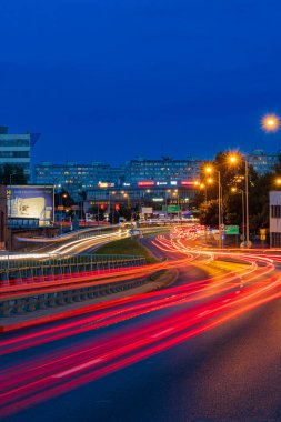 Wroclaw, Poland - August 24 2023: Long streaks of light made by riding cars on the road on the bridge at cloudy afternoon