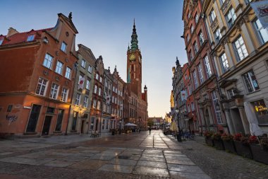 Gdansk, Polonya - 6 Eylül 2023: Her iki tarafında eski binalar ve sonunda güzel ve yüksek kırmızı tuğlalı belediye binaları olan güzel uzun ve eski Dluga caddesi