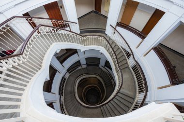 Varşova, Polonya - 15 Ekim 2023: Şehir merkezinde güzel yıldızlı eski bir apartmanın içindeki güzel ve eski spiral merdiven 