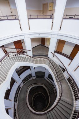 Varşova, Polonya - 15 Ekim 2023: Şehir merkezinde güzel yıldızlı eski bir apartmanın içindeki güzel ve eski spiral merdiven 