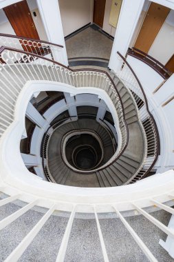 Varşova, Polonya - 15 Ekim 2023: Şehir merkezinde güzel yıldızlı eski bir apartmanın içindeki güzel ve eski spiral merdiven 