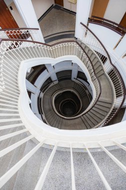 Varşova, Polonya - 15 Ekim 2023: Şehir merkezinde güzel yıldızlı eski bir apartmanın içindeki güzel ve eski spiral merdiven 