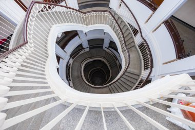 Varşova, Polonya - 15 Ekim 2023: Şehir merkezinde güzel yıldızlı eski bir apartmanın içindeki güzel ve eski spiral merdiven 