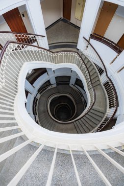 Varşova, Polonya - 15 Ekim 2023: Şehir merkezinde güzel yıldızlı eski bir apartmanın içindeki güzel ve eski spiral merdiven 