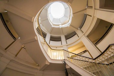 Varşova, Polonya - 15 Ekim 2023: Şehir merkezinde güzel yıldızlı eski bir apartmanın içindeki güzel ve eski spiral merdiven 