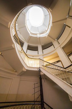 Varşova, Polonya - 15 Ekim 2023: Şehir merkezinde güzel yıldızlı eski bir apartmanın içindeki güzel ve eski spiral merdiven 