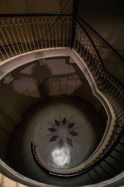Varşova, Polonya - 15 Ekim 2023: Şehir merkezinde güzel yıldızlı eski bir apartmanın içindeki güzel ve eski spiral merdiven 
