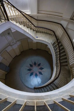 Varşova, Polonya - 15 Ekim 2023: Şehir merkezinde güzel yıldızlı eski bir apartmanın içindeki güzel ve eski spiral merdiven 