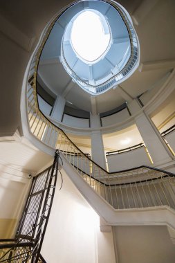 Varşova, Polonya - 15 Ekim 2023: Şehir merkezinde güzel yıldızlı eski bir apartmanın içindeki güzel ve eski spiral merdiven 