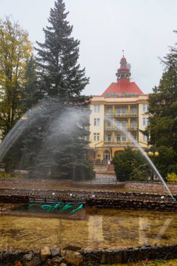 Polanica-Zdroj, Polonya - 20 Ekim 2023: Geceleri Wielka Pieniawa Sanatoryumu önünde parka su sıçrayan güzel bir çeşme