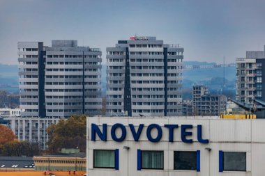 Wroclaw, Polonya - 12 Kasım 2023: Bulutlu bir öğleden sonra şehrin merkezinde Novotel 'in yüksek binasının arkasındaki Atal Kulelerinin güzel manzarası