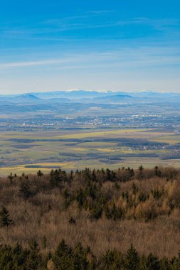 Beautiful view of mountain range covered with fog seen from viewing tower at sunny morning at winter clipart