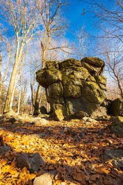 Kışın güneşli bir günde, dağ patikasının yanında birkaç küçük ve dev kaya oluşumu.